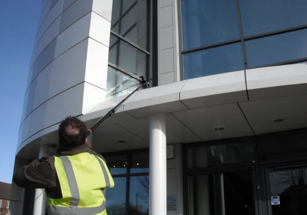 Window cleaner cleaning the glazing of a modern commercial building